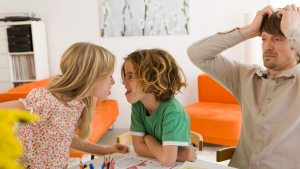 two children fighting while exasperated parent looks on